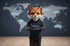 Ein Fuchs mit Kopfhörern und Kapuzenpullover hält ein Tablet vor einer Weltkarte mit digitalen Verbindungen.