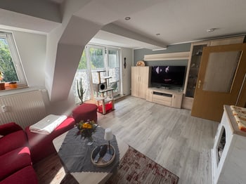 Wohnzimmer mit Sitzgruppe, Fernsehwand und Dachschräge