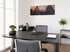 Moderner Arbeitsplatz mit schwarzem Schreibtisch, Bürostuhl, Bonsai, Blumen und einem Wandbild von Borobudur Stupas.