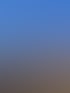 Ziegeldach mit Solarmodulen, Gaube und blauer Himmel mit Wolken.
