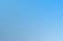 Hände halten ein Tablet mit einer Kompass-App vor einem unscharfen blauen Wegweiser und blauem Himmel.