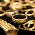 Verschiedene goldene Ringe und Ketten auf schwarzem Hintergrund.