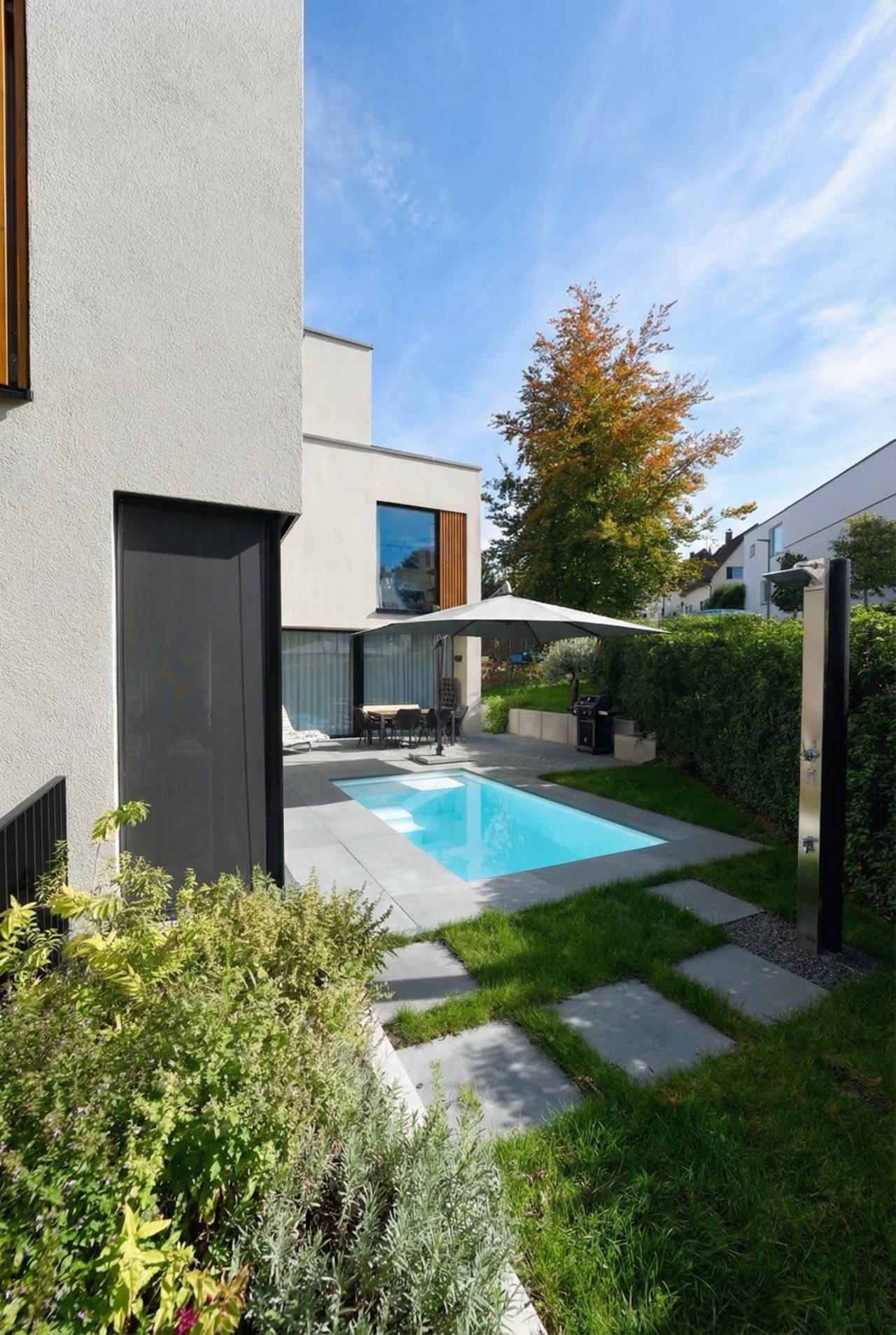 Moderner Garten mit rechteckigem Pool und grauer Umrandung