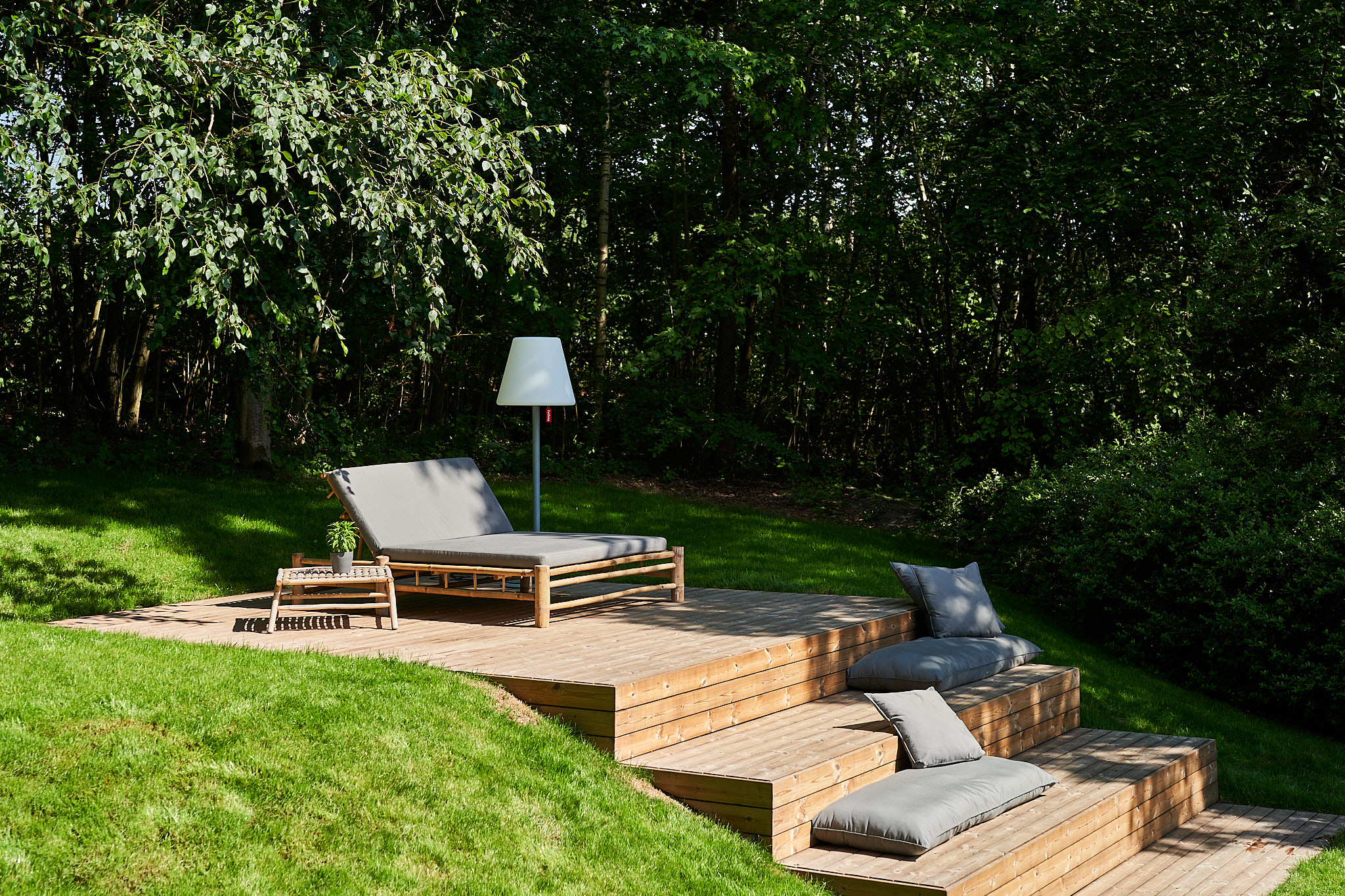 Holzterrasse mit Sitzbereich in einem begrünten Garten