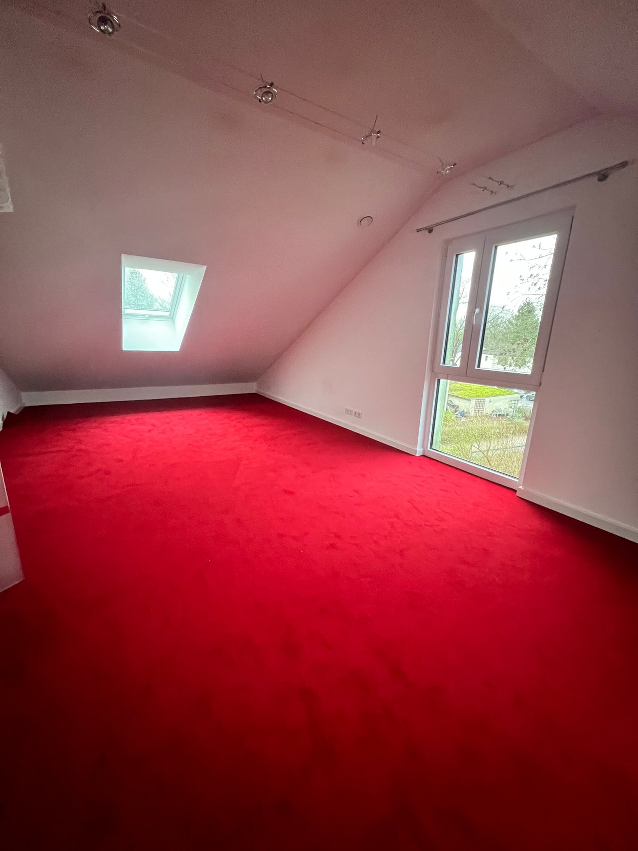 Dachzimmer vor der Sanierung mit rotem Teppichboden
