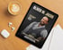 Tablet mit Oliver M. Jacob Cover, Kaffeetasse, Kopfhörer und Notizblättern auf Holztisch.