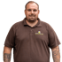Ein lächelnder Mann in einem braunen Poloshirt mit dem Logo „GARTEN von KARP“ auf der Brust.