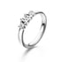 Silberner Ring mit drei quadratischen Diamanten in einer Reihe auf weißem Hintergrund.