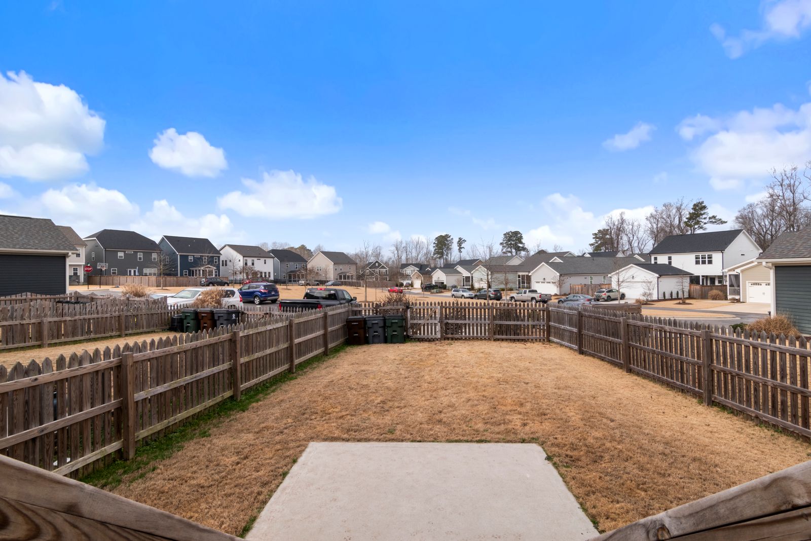 Modern fenced back yard behind suburban homes