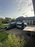 Zwei Mercedes Campervans auf dem Hof einer Reisemobil-Werkstatt – individuelle Kastenwagenausbauten für autarkes Reisen in professioneller Umgebung