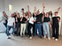 Gruppenfoto von doQtor Teammitgliedern, die sich freuen und die Arme nach oben schweißen