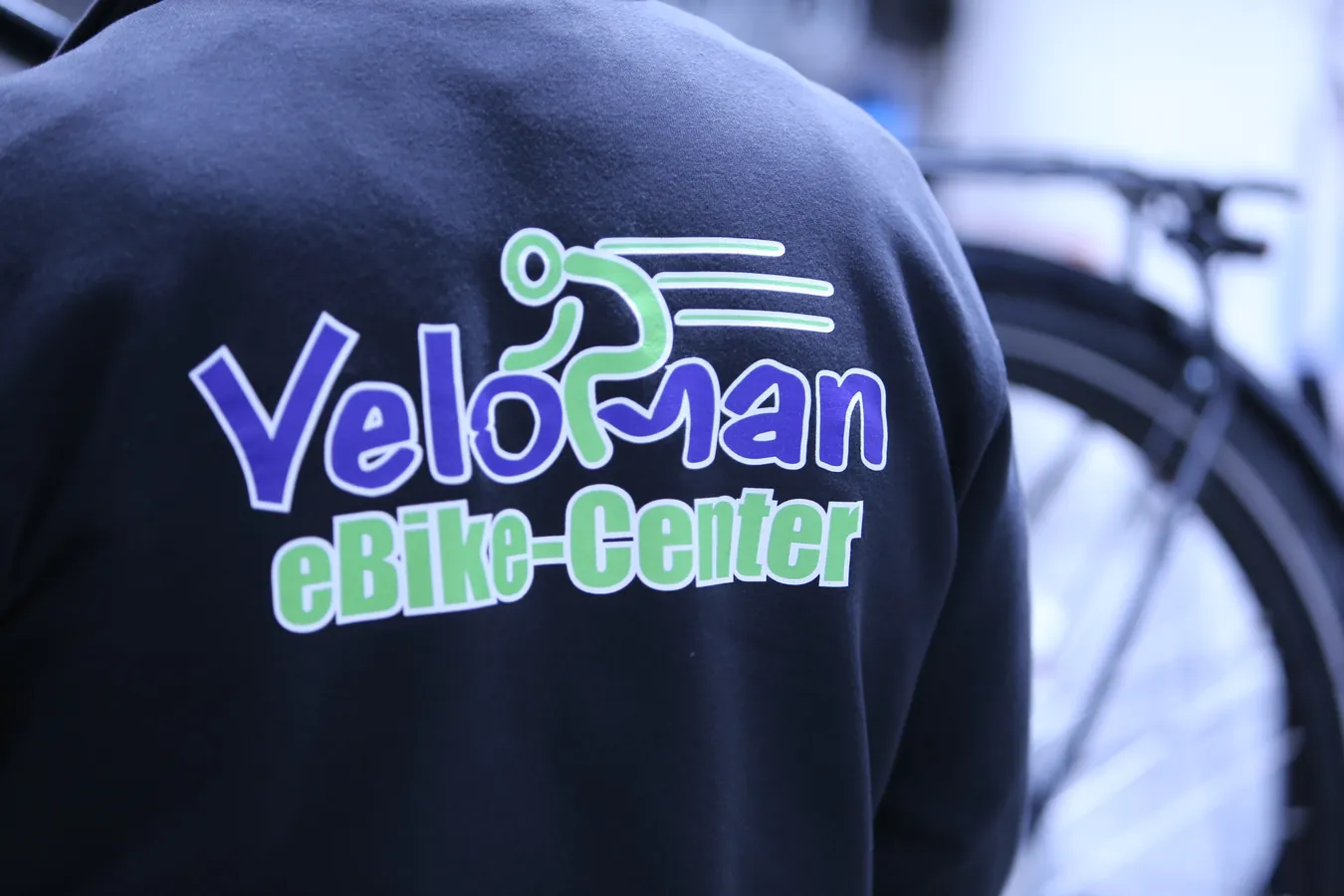 Veloman eBike-Center Logo auf der Arbeitsjacke
