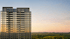 Modern high-rise building with reflective windows at sunrise, overlooking a green forest and clear sky.