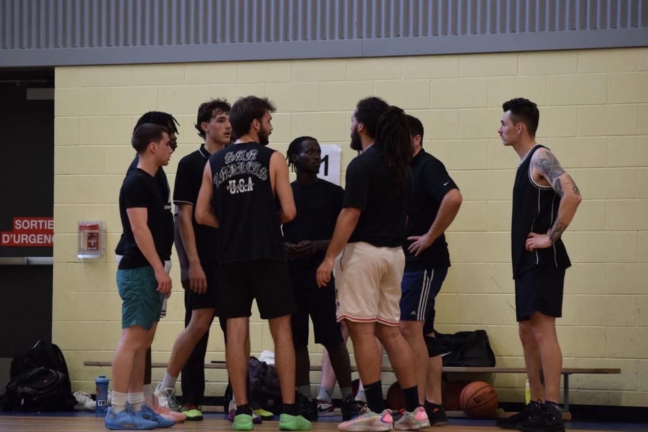 Des joueurs de basketball rassemblés au centre du terrain