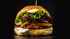 Saftiger Vegan-Burger mit Salat, Tomate, Zwiebeln und Soße auf dunklem Hintergrund.