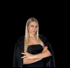 Junge blonde Frau in schwarzem Kleid und Jacke mit verschränkten Armen vor schwarzem Hintergrund.