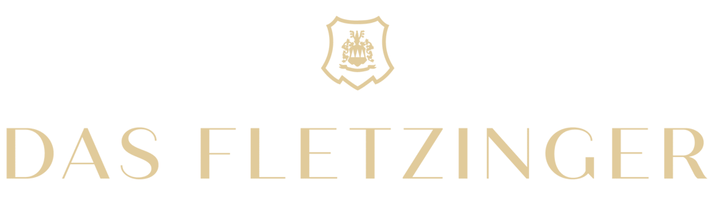 Beiges Wappen über dem Text "DAS FLETZINGER" auf grünem Hintergrund.