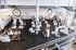 Blick von oben auf einen Fitnessraum mit vielen weißen und braunen Trainingsgeräten und hängenden Lampen.