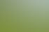 Ein orangefarbener Hangmäher mäht hohes Gras an einem steilen, grünen Berghang vor einer Waldkulisse.