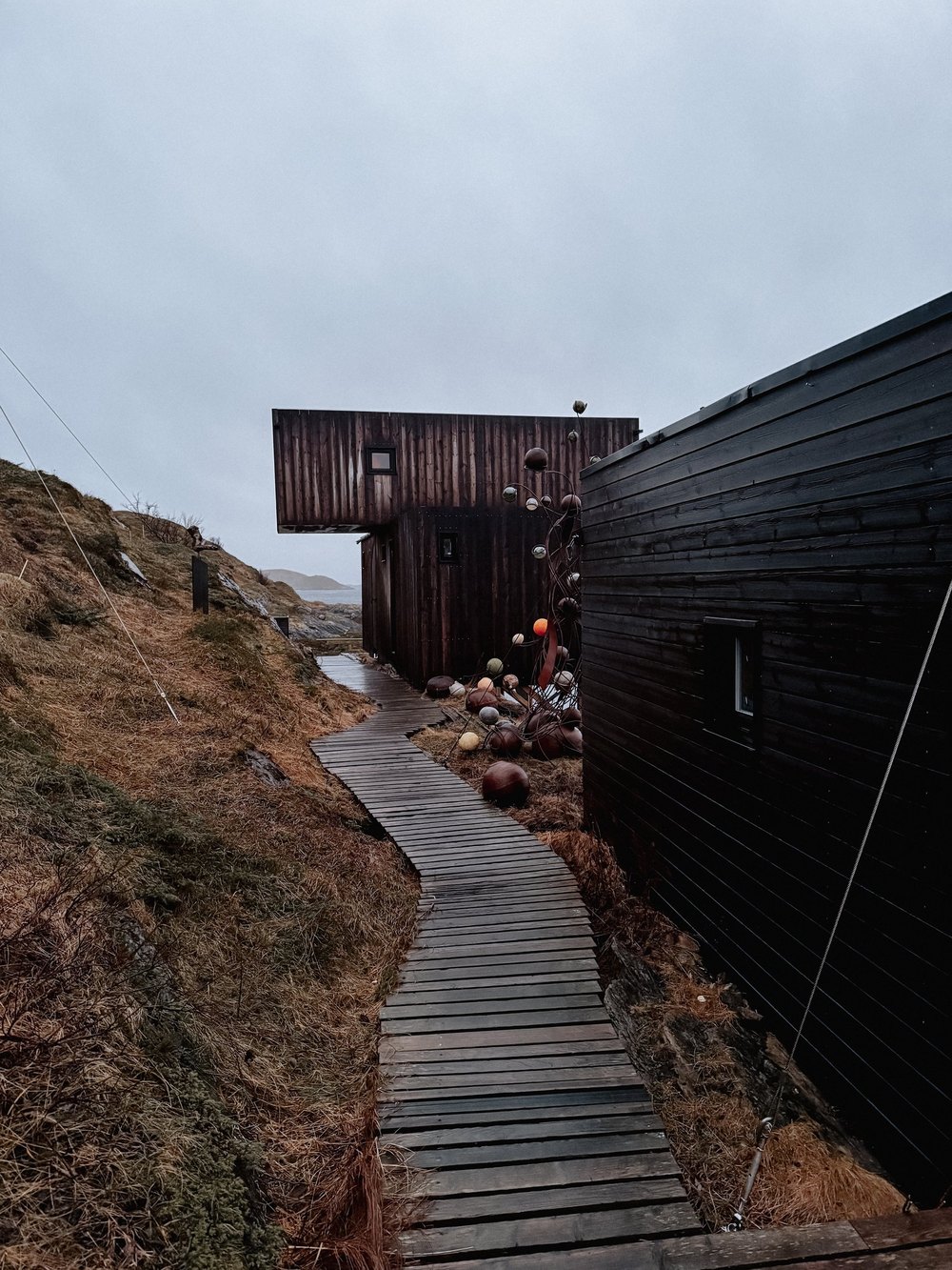 Holzweg entlang einer dunklen Hütte
