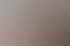 Vier lachende Personen sitzen an einem Besprechungstisch vor einem großen Monitor in einem modernen Büro mit Dachschrägen.