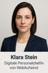 Klara Stein, digitale Personalchefin von WebAufwind, trägt eine dunkelblaue Jacke über einem weißen Oberteil.