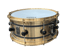 Snare-Drum aus gebürstetem Messing mit schwarzen Spannböckchen und weißem Evans-Schlagfell vor schwarzem Hintergrund.
