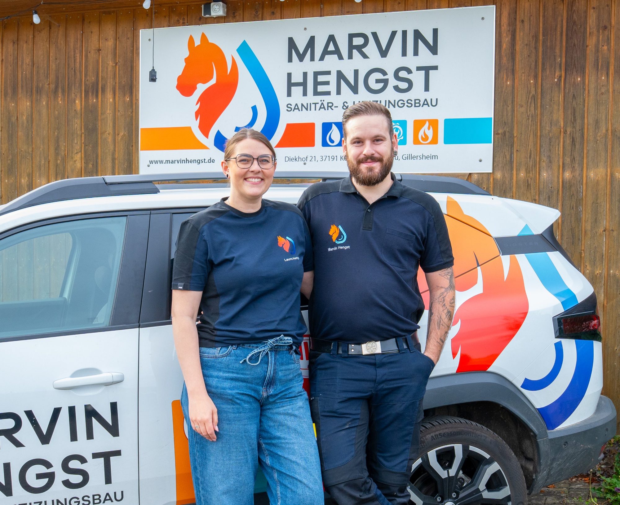 Laura und Marvin Hengst vor dem Firmenschild