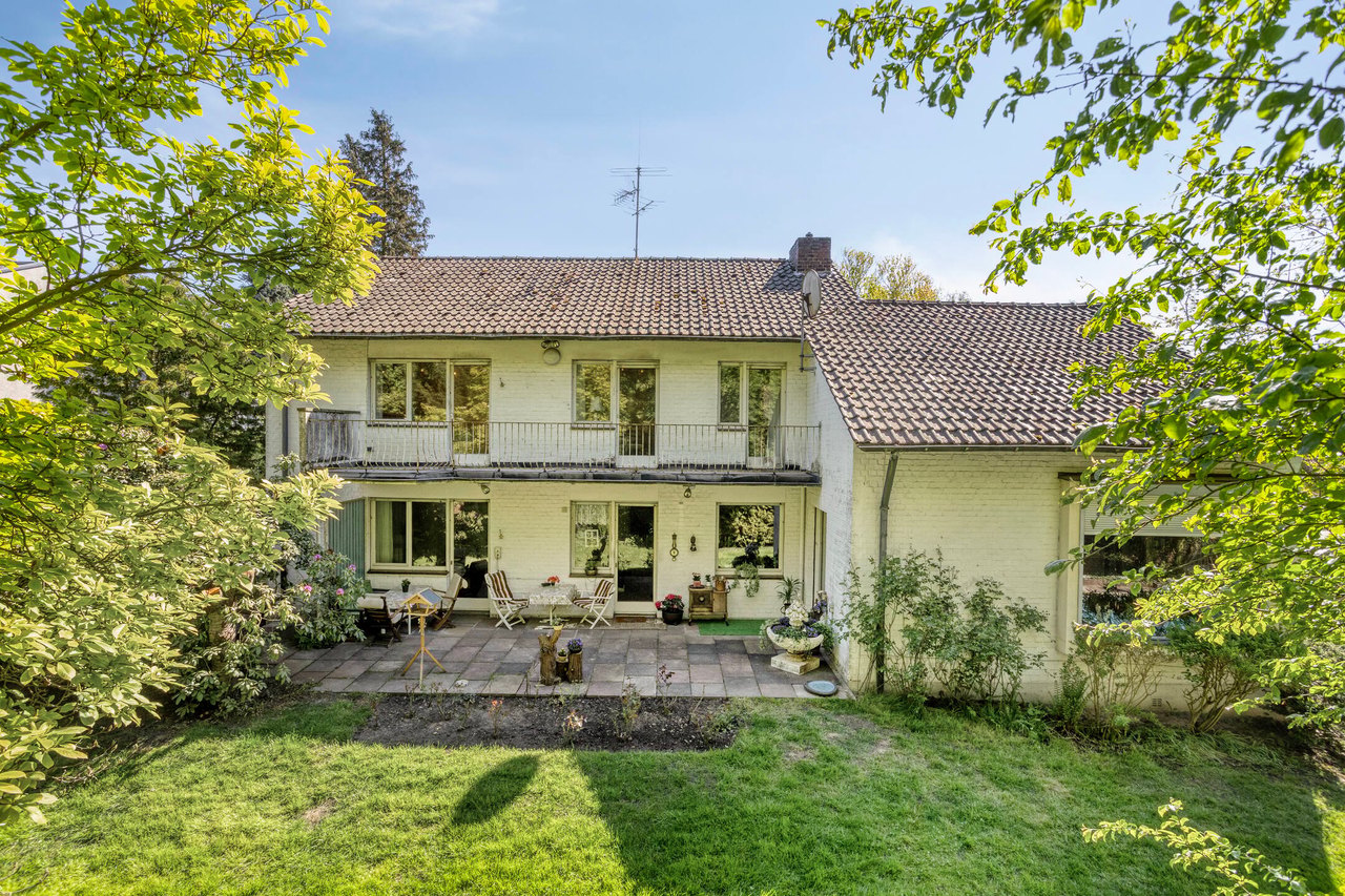 Gartenseite mit überdachter Terrasse und Balkon im Obergeschoss