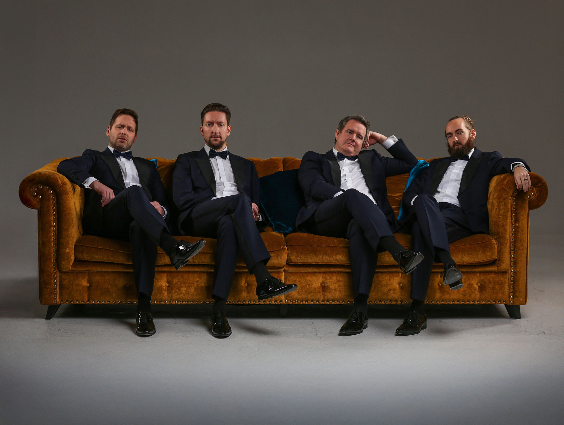 Ringmasters, barbershop quartet from Sweden, in black tie on a velvet sofa