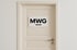 Eine cremefarbene Tür mit einem Schild mit der Aufschrift "MWG" in Großbuchstaben und einem horizontalen Strich darunter.