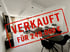 Modernes Wohnzimmer mit Esstisch, Sofa und Couchtisch; roter Stempel "VERKAUFT FÜR 249.000 €".