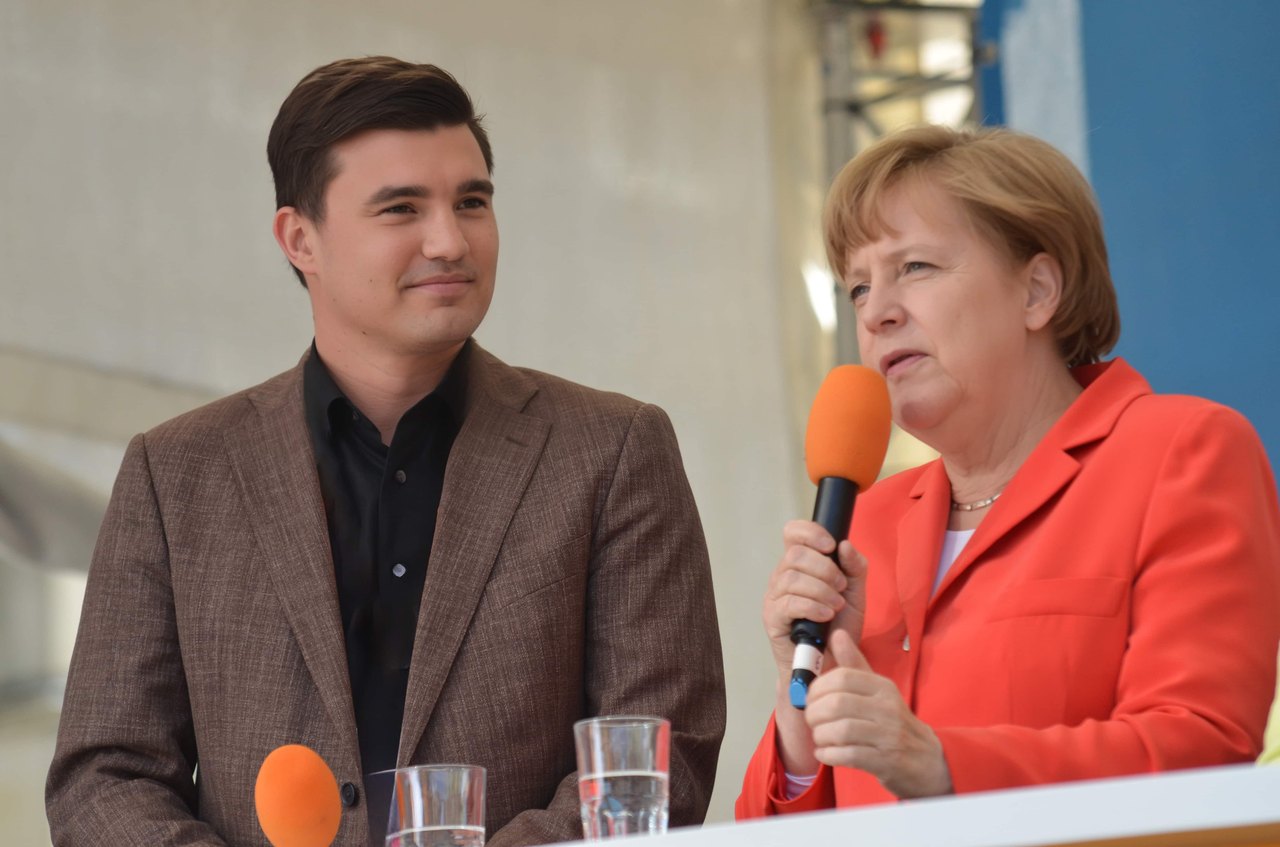 Tim Christopher Gasse moderiert 2015 eine Veranstaltung mit Bundeskanzlerin Angela Merkel in Bremen