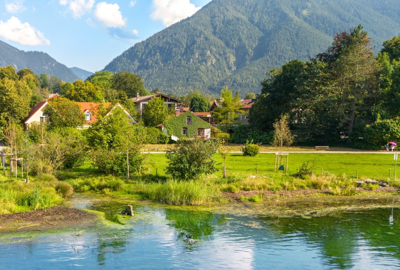 Blick von der Seeseite über die öffentliche Uferwiese mit Fußweg auf das Grundstück und das Bestandsgebäude