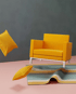 3D-Rendering eines Sessels mit herumfliegenden Kissen, dargestellt als Einzelbild mit realistischen Texturen.