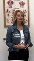 Woman in a denim jacket talking with "I DON'T THINK" text overlay, standing in front of an anatomical chart.