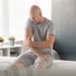 Man sits holding his elbow, seeking relief through stem cell therapy.