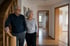 Älteres Paar im Flur eines Hauses mit Treppe und leeren Zimmern im Hintergrund