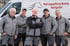 Fünf Mitarbeiter von Wohnungsauflösung Mustang Hennigsdorf stehen lächelnd vor einem weißen Firmenwagen mit Logo.