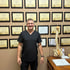 Dr. Keith Currie smiling among certificates and a spine model.
