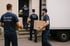 Vier Umzugshelfer in blauen T-Shirts mit "Zentral Umzüge" tragen Kartons zu einem Umzugswagen.