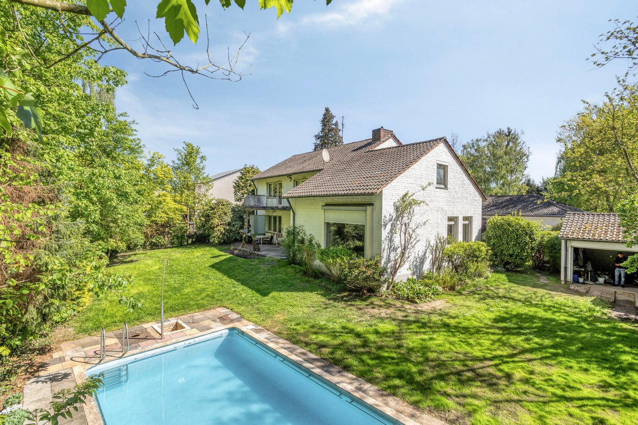 Außenpool im Garten, dahinter das Haus