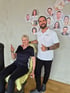 Mitglied Hella beim Training mit LANDphysio-Sporttherapeut Peter vor der Teamwand im Gesundheitsstudio Lauchdorf, Ostallgäu