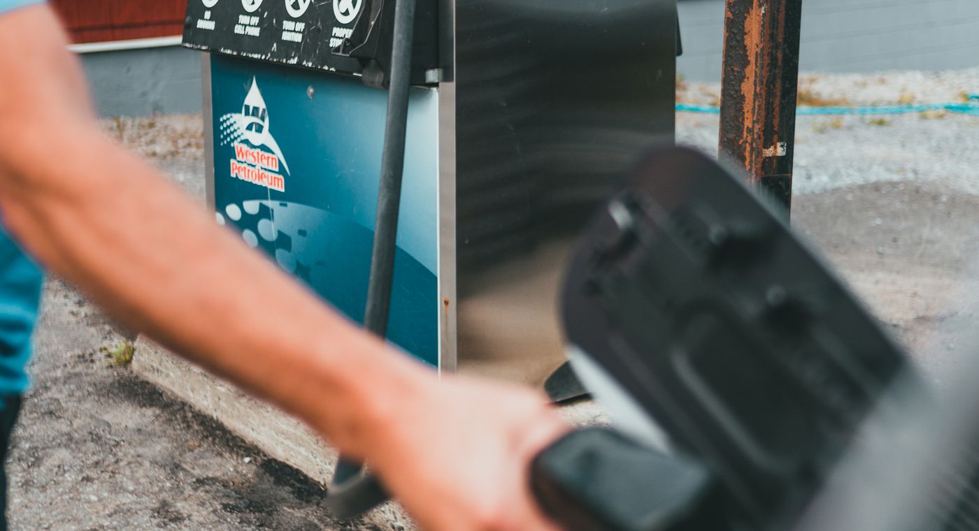 run out of gas on the highway: pouring fuel from a portable gas can into a car's tank on the roadside near Orlando, FL