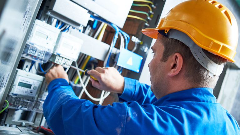 Elektrofachkraft prüft den Sicherungskasten während der energetischen Bestandsaufnahme
