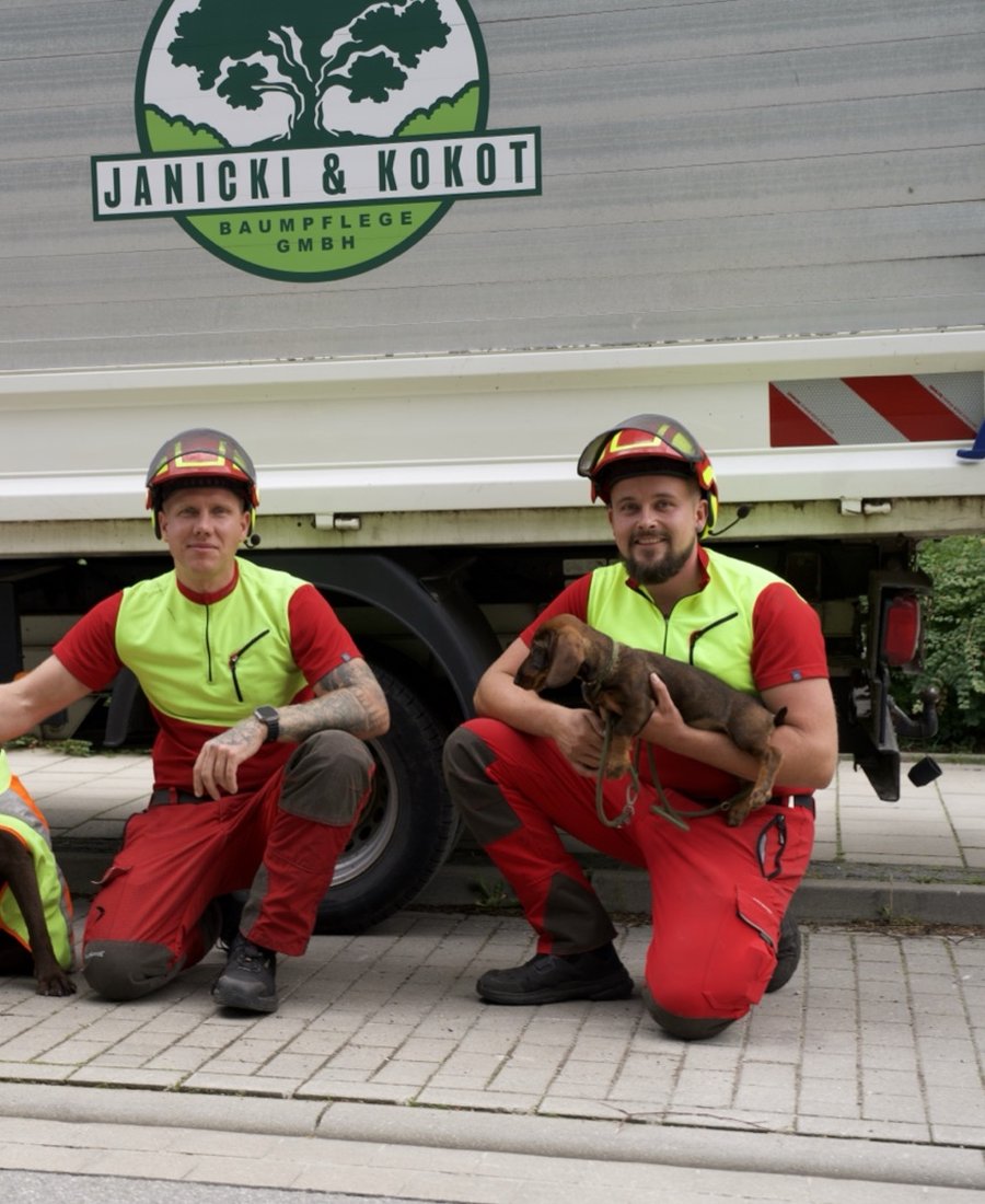 Mateusz Janicki und Paul Kokot mit den Firmenhunden vor dem Einsatzfahrzeug