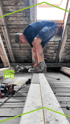 Handwerker arbeitet auf einem Dachboden an Holzbalken mit MFR Logo Einblendung.