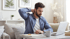 Man rubbing his neck while working, dealing with discomfort from a herniated disc