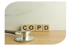 Hölzerne Blöcke buchstabieren COPD mit einem Stethoskop davor auf einem Holztisch.