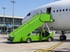 Förderung für elektrische Fluggasttreppen am Flughafen: grüne Elektro-Passagiertreppe steht an einem Flugzeug auf dem Vorfeld